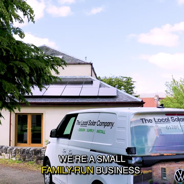 James, director of The Local Solar Company, with the company van outside a house with solar panels